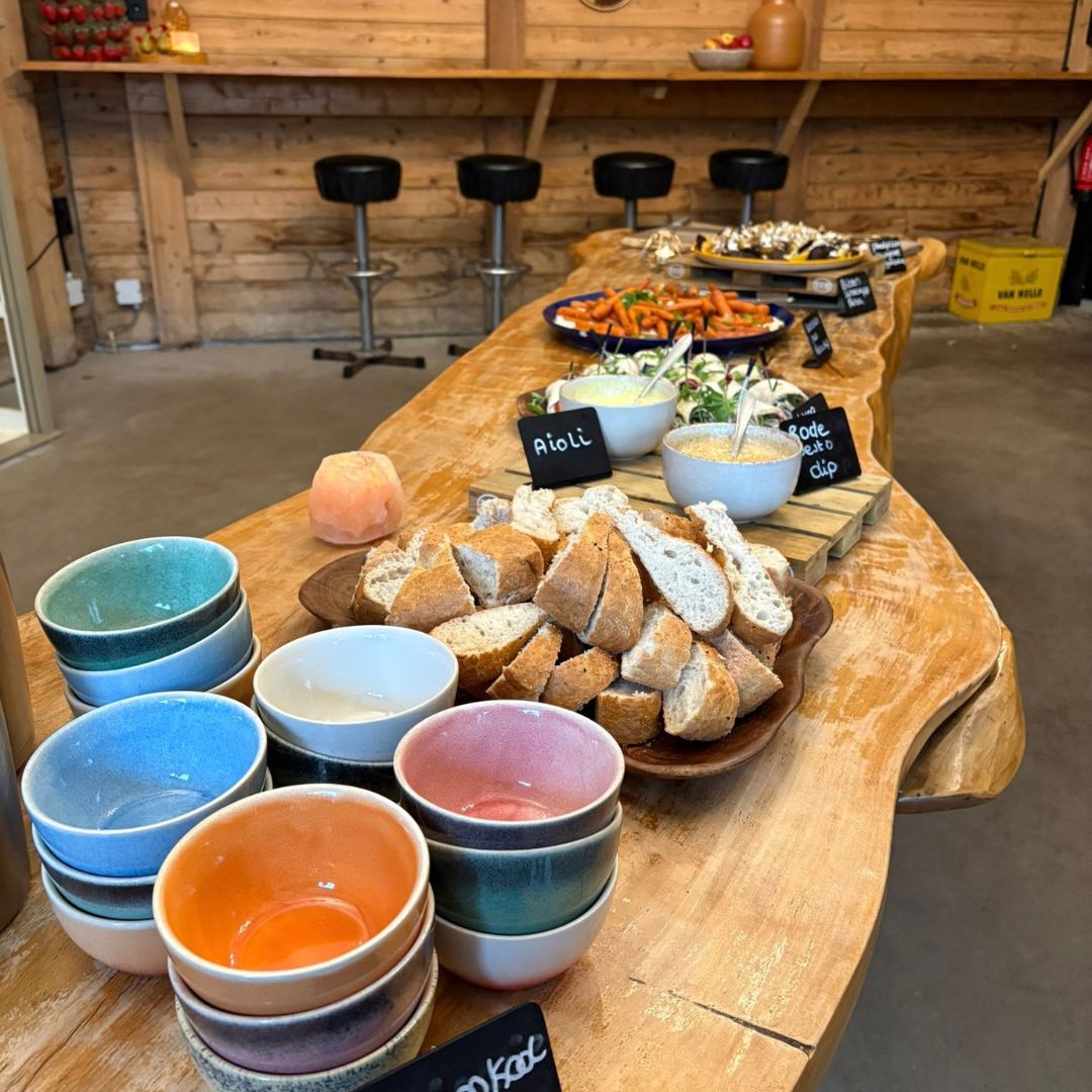 De lunchtafel met brood, dips en kleurrijke schaaltjes